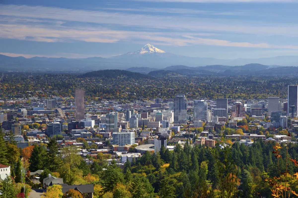 This image captures a panoramic view of Mount Hood, the downtown Portland skyline, and lush green trees, evoking a sense of the Oregon landscape. The scene highlights the natural beauty and adventure awaiting just beyond the villa, tying directly into the wine country exploration theme.