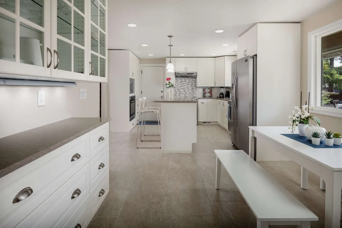 A modern, airy kitchen and dining area with a spacious island, white cabinetry, and seating. The layout feels open and sociable, ideal for gathering before or after outdoor adventures.