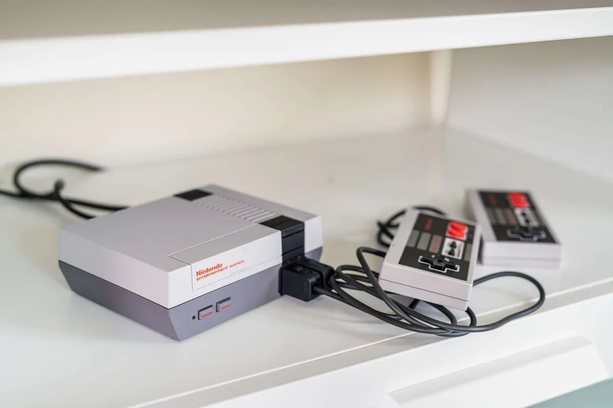The photo features a classic Nintendo Entertainment System set up with controllers, inviting video gaming sessions. The nostalgic gaming console takes center stage against a simple, cozy backdrop, emphasizing play and shared laughter.